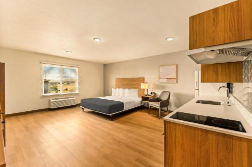 a hotel room with a bed and a kitchen at LivAway Suites Portland- Scarborough in Scarborough