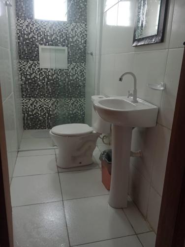 a bathroom with a toilet and a sink and a shower at Pousada San Valen in Aparecida