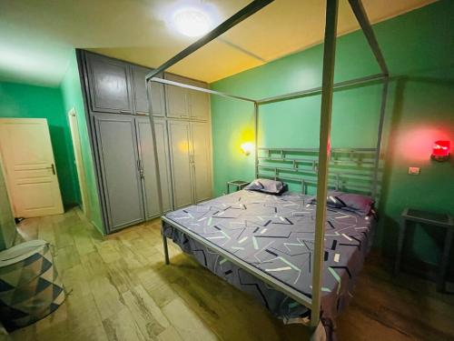 una camera da letto con un letto in una stanza con pareti verdi di The Quiet Corner a Dakar