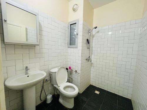 un bagno bianco con un water e un lavandino di The Quiet Corner a Dakar