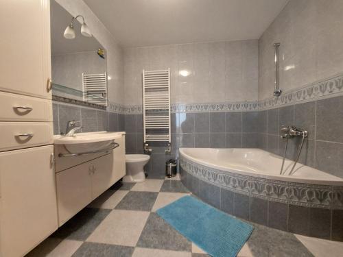 a bathroom with a tub and a toilet and a sink at Apartma Teloh in Kopačnica