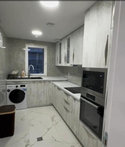 a kitchen with white cabinets and white appliances at Crater H in Kukrike