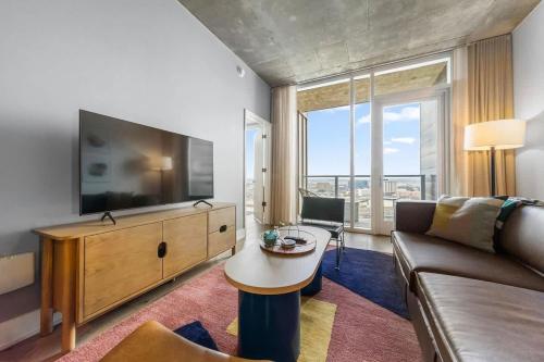 a living room with a couch and a flat screen tv at Frisco at the Rainey District in Austin