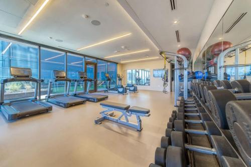 a gym with cardio equipment and chairs in a building at Frisco at the Rainey District in Austin