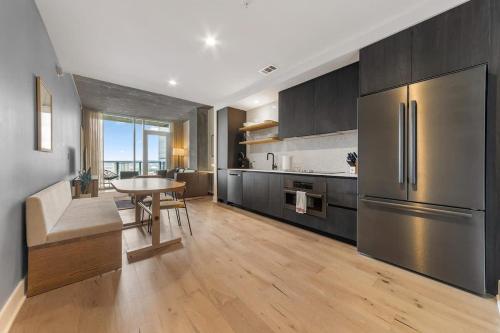 a kitchen with a table and a stainless steel refrigerator at Frisco at the Rainey District in Austin