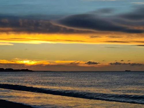 a sunset on the beach with the ocean at 6 person holiday home in Thisted-By Traum in Torsted