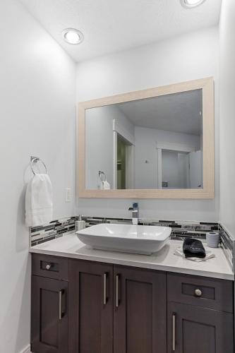 a bathroom with a sink and a large mirror at Hearthside Estate in Prince George