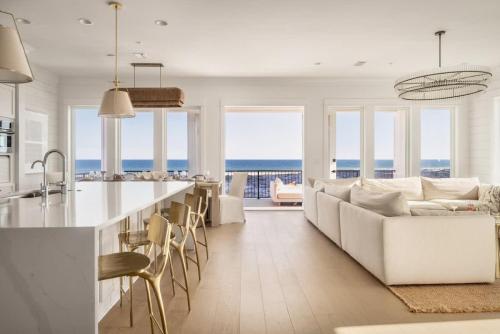 a kitchen and living room with a couch and a table at Whitecap - Beachfront Gem with Pool & Elevator in Orange Beach
