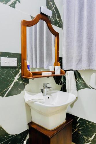 a bathroom with a sink and a mirror at Elisach Serenity House - 4 BHK Villa in Sri Lanka - near to Airport in Negombo