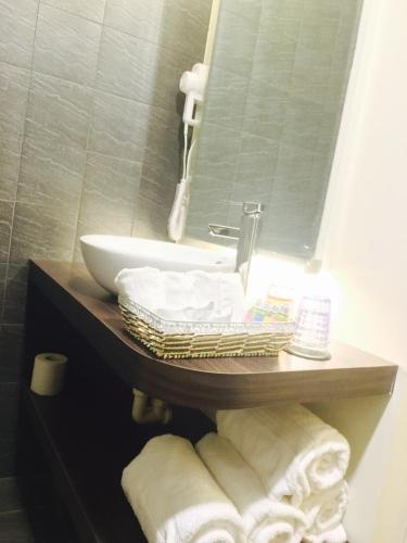 a bathroom with a sink and a mirror and towels at Kenting A&S in Hengchun