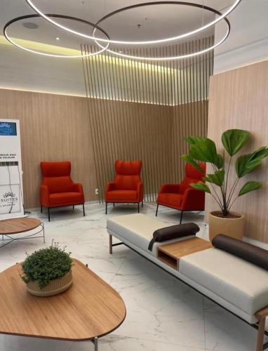 a waiting room with red chairs and a couch at Nobre Hotel Aeroporto Congonhas UH504 in Sao Paulo