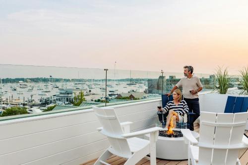 a man and a woman standing on a balcony with a fire place at Newport Marriott Hotel & Spa in Newport