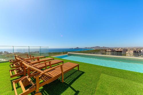 a row of wooden benches sitting on top of a building at Torre San Angel Infinity Pool Arch Sunset Views in Cabo San Lucas