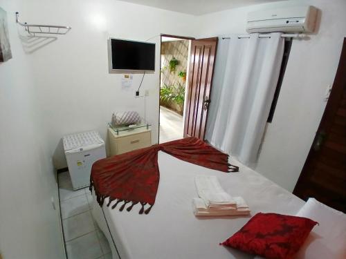 a room with a bed with a red blanket on it at Pousada Aconchego do Tambaú in João Pessoa