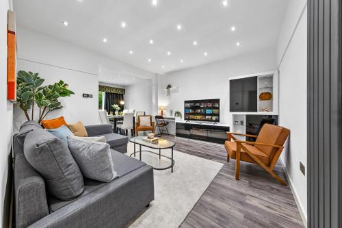a living room with a couch and a table at Large Group StayI 5BR I Near Stadium & Tubes I Free Parking in London