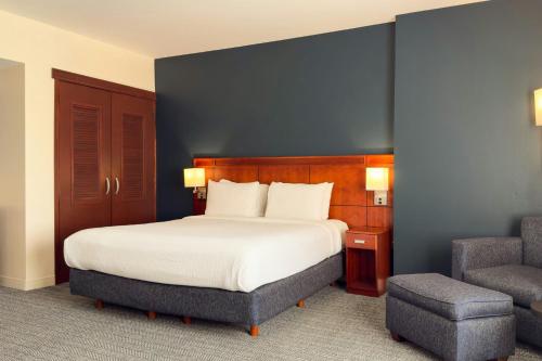 a bedroom with a large bed and a chair at Courtyard Toluca Tollocan in Toluca