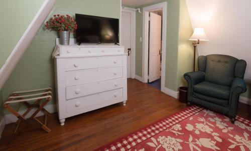 a living room with a dresser with a tv on it at The Monadnock Inn in Jaffrey