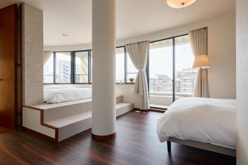 a bedroom with a bed and a large window at Noël Shibuya Once -Luxury Residence in Tokyo