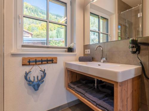 un bagno con lavandino e finestra di Tauernlodge Berglust a Bramberg am Wildkogel