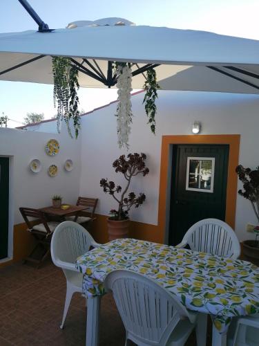 a table with white chairs and a blue and yellow table cloth at A casa da Carolina II in Mértola