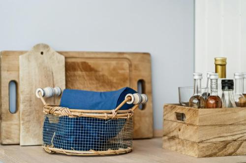 a basket with bottles of wine and a wooden box at Cabin By Forest And Beach In Havhusene in Hornslet