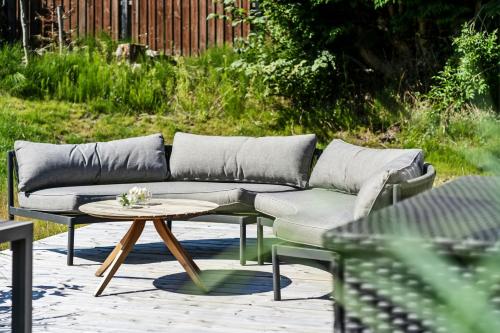 a couch and a coffee table on a patio at Cabin By Forest And Beach In Havhusene in Hornslet