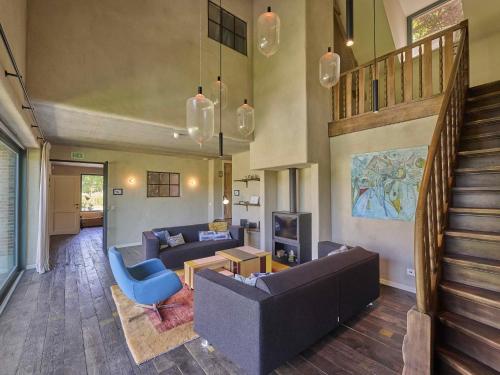 a living room with a couch and a table and a staircase at Villa Lactea in Schilde