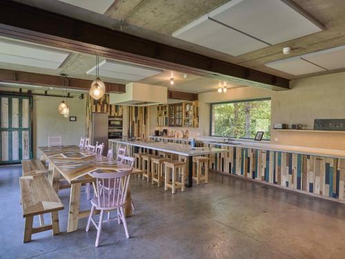 a restaurant with wooden tables and chairs and a kitchen at Villa Lactea in Schilde