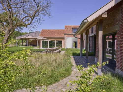 an old brick building with a porch and a yard at Villa Lactea in Schilde