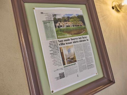 a picture of a newspaper in a frame on a wall at Villa Lactea in Schilde