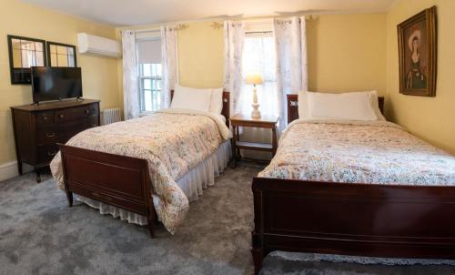 a bedroom with two beds and a television in it at The Monadnock Inn in Jaffrey