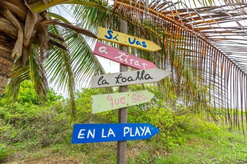 a street sign with many different signs on it at CasaPiedra in Puerto Escondido