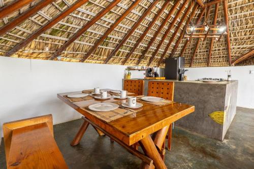 a wooden table in a room with a kitchen at CasaPiedra in Puerto Escondido
