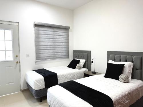 a bedroom with two beds and a window at Encanto de Playa Sur By GEstores in Mazatlán