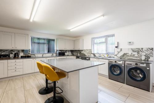 a white kitchen with a washer and dryer at Sleek Luxe Room - Contractor and Holiday Stay in Coventry