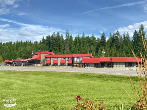 a building with red roofs and a green field at Wells Gray Inn in Clearwater
