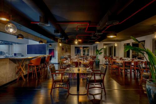 a restaurant with tables and chairs and a bar at Gulf Hotel Bahrain Convention and SPA in Manama