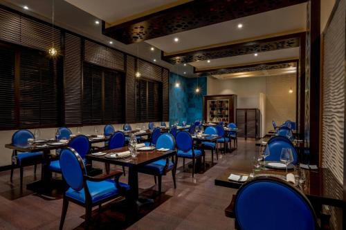 a dining room with blue chairs and tables at Gulf Hotel Bahrain Convention and SPA in Manama