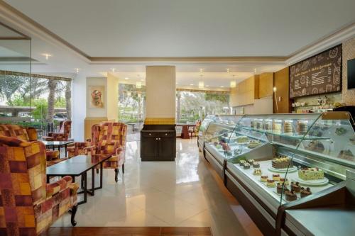 a restaurant with a buffet of food on display at Gulf Hotel Bahrain Convention and SPA in Manama