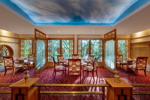 a room with a table and chairs and windows at Gulf Hotel Bahrain Convention and SPA in Manama