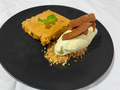 a black plate with a piece of cake and a desert at Belcruz family lodge in Monteverde Costa Rica