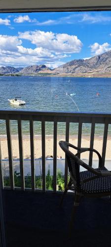 a chair sitting on a balcony overlooking a body of water at Richter Pass Beach Resort in Osoyoos