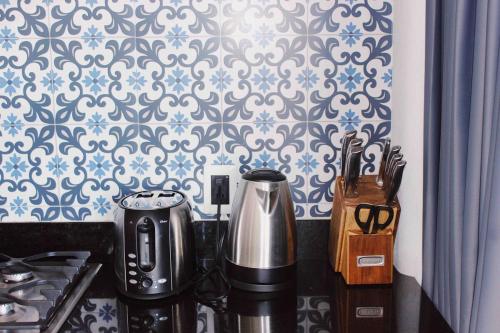 a kitchen counter with a coffee maker and a wall at Makawe in Sayulita