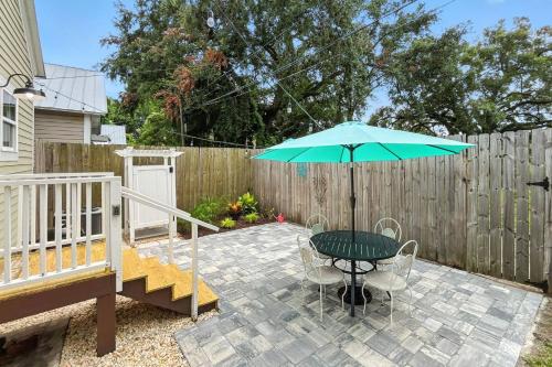 a patio with a table and an umbrella at Odie's Oasis on Union in Brunswick