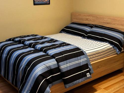 a bed with black and white striped sheets on it at Vito Place in Halifax
