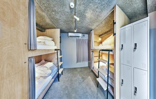 a room with three bunk beds in a room at Hotel URO in Nagasaki