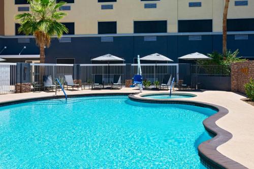 a pool at a hotel with chairs and umbrellas at Fairfield by Marriott Inn & Suites Phoenix West Chandler in Phoenix