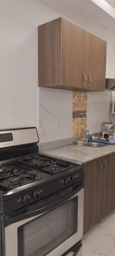 a kitchen with a black stove and wooden cabinets at Golden Sun Penthouse VIP in Playa Blanca