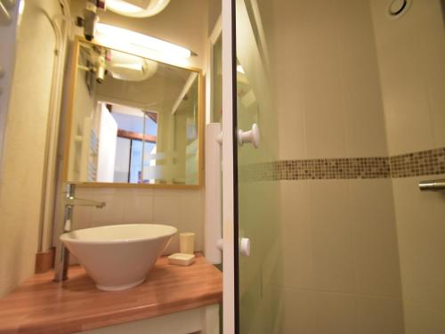 a bathroom with a sink and a glass shower at Cottage in Central Bayeux in Bayeux