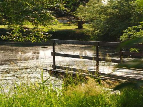 a wooden bridge over a river in a field at Holiday Home in Gargas with Pool and Nature in Gargas